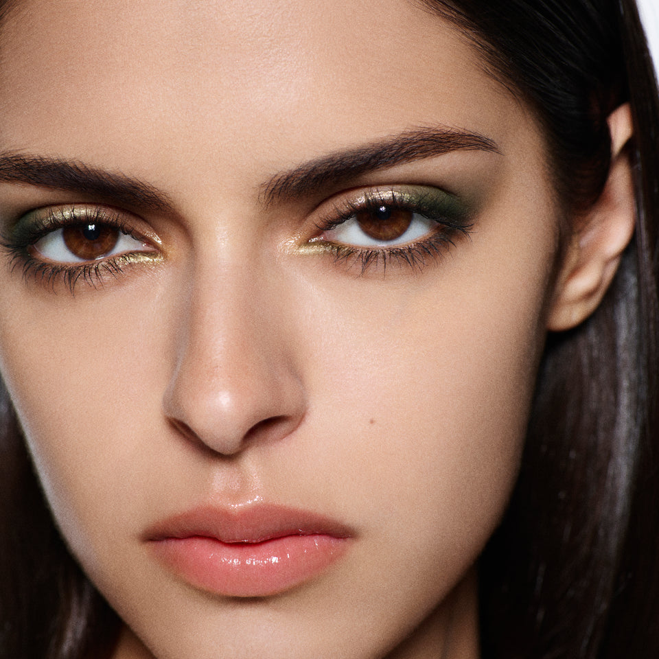 Close-up of an olive green and gold shimmer eye with a peach gloss lip — Victoria Beckham Beauty Olive Eye Kit look.