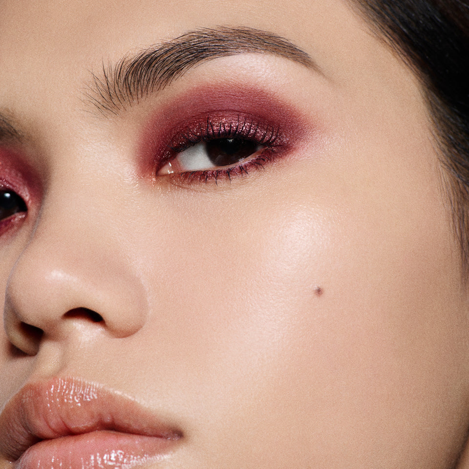Close-up of a burgundy and bronze shimmer smoky eye on a light-complexion model — Victoria Beckham Beauty Bordeaux Eye Kit look.