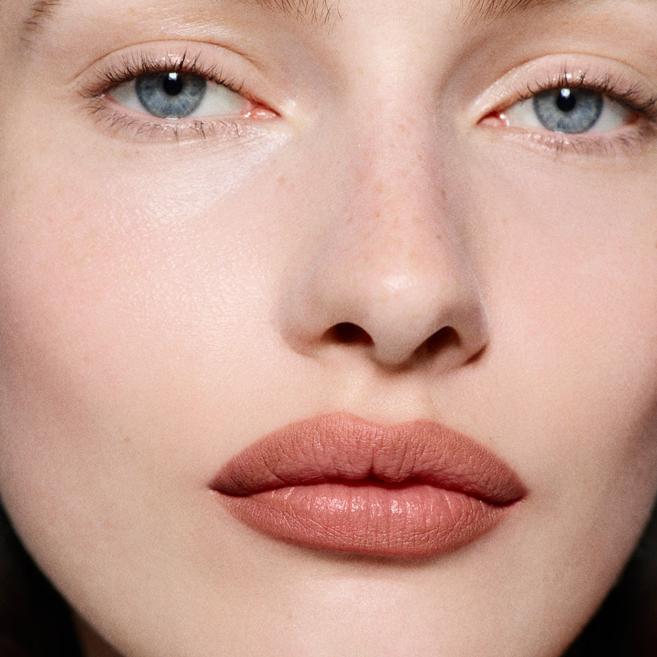 Close-up of fair lips lined in Lip Definer No. 1.5 — Victoria Beckham Beauty's warm rosy-taupe lip pencil.