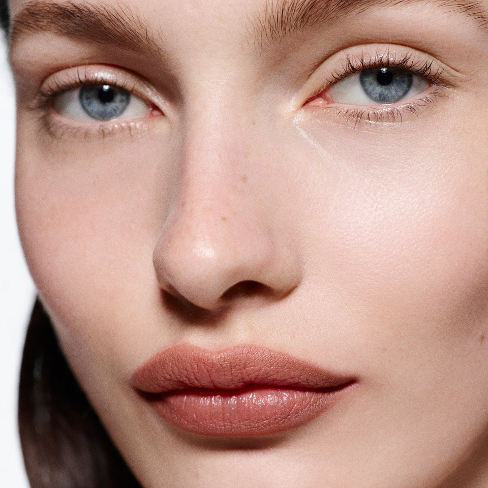 Close-up of fair lips lined in Lip Definer No. 1.5, angled view — Victoria Beckham Beauty's warm rosy-taupe lip pencil.