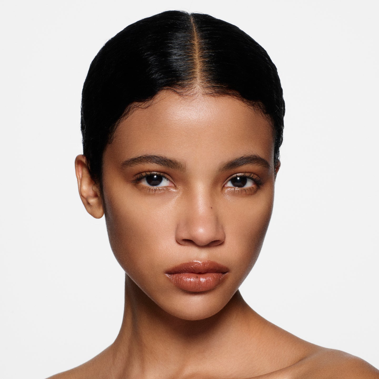 Close-up of a woman with a neutral expression on a white background