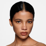 Close-up of a woman with a neutral expression on a white background