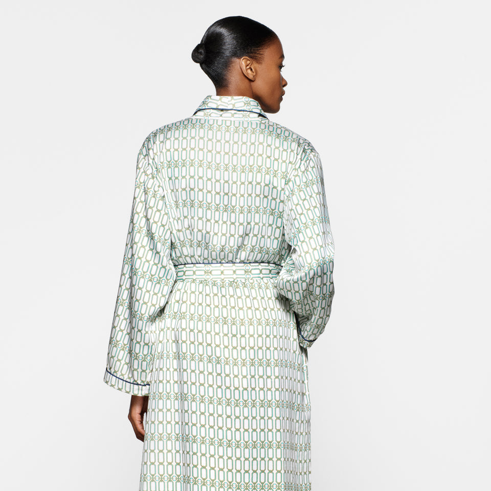 Back view of a model with a low bun wearing the Portofino '97 robe in turquoise and gold chain-link print.