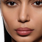 Macro of lips on olive complexion in Posh Gloss Cabana, Victoria Beckham Beauty's dusty rose pink mirror-shine gloss.
