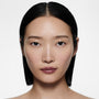 Light-complexion model with a sleek centre-parted black bob in Posh Lip Jump — mauve berry by Victoria Beckham Beauty.
