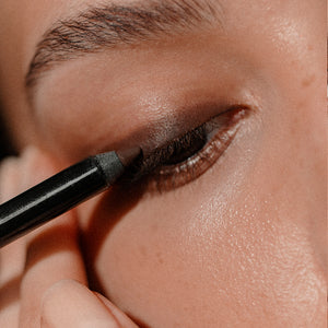 Close-up image of a model's eye, applying the Satin Kajal Liner to the eyelid.