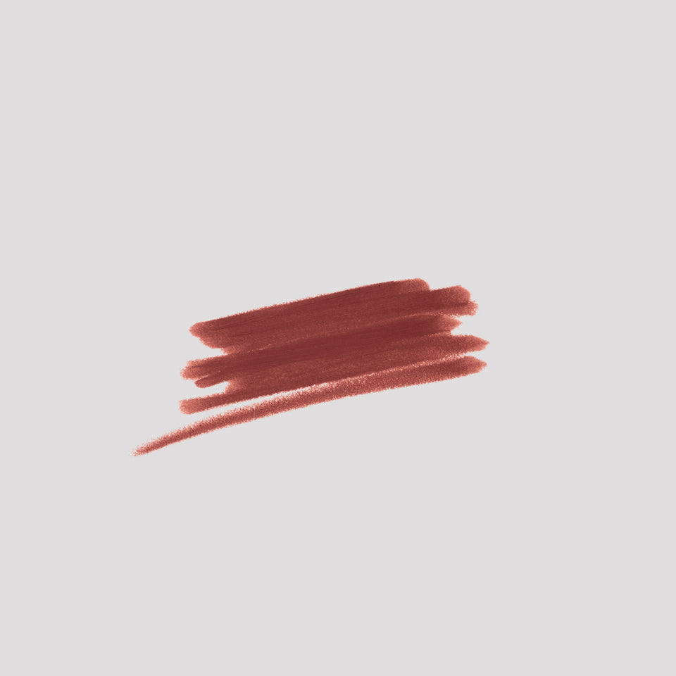 Swatch of Lip Definer No. 04 on grey backdrop — Victoria Beckham Beauty's brick red-brown lip pencil texture.