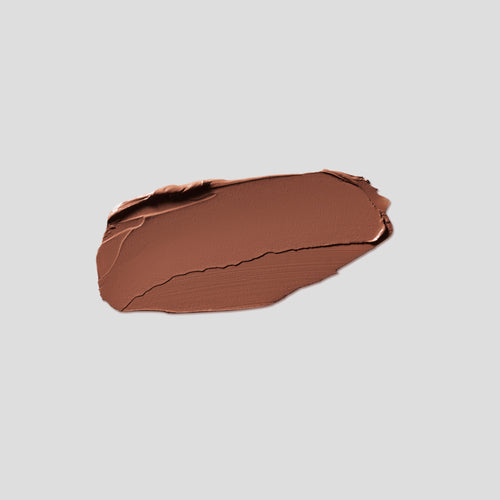 Brushstroke swatch of Contour Stylus Marble on grey backdrop — Victoria Beckham Beauty cool medium brown contour stick.