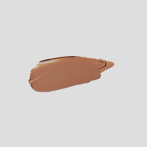 Brushstroke swatch of Contour Stylus Travertine on grey backdrop — Victoria Beckham Beauty warm medium brown contour stick.