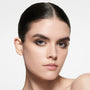 Fair-skinned model with slicked-back dark hair and a smoked lash line in Satin Kajal Liner Cocoa Pavé — Victoria Beckham Beauty.