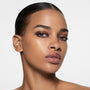 Deep-complexion model with slicked-back hair in a soft cocoa smoky eye — Victoria Beckham Beauty Cocoa Eye Edit.