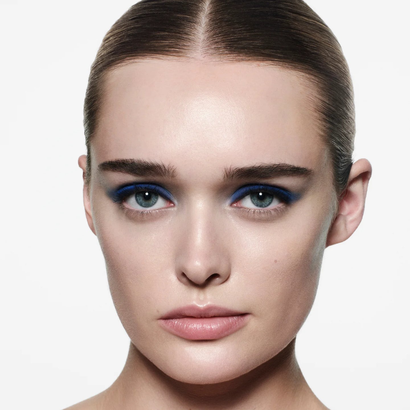 Model wearing Victoria Beckham Beauty Eye Wardrobe in Navy Noir – a bold, modern eyeshadow look featuring vibrant cobalt blue, deep navy, and soft blue tones for a striking, high-fashion finish.