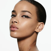 Model wearing Victoria Beckham Beauty Eye Wardrobe in Night Flash – a striking eyeshadow look featuring bold black, shimmering taupe, and soft ivory tones for a modern, graphic finish.