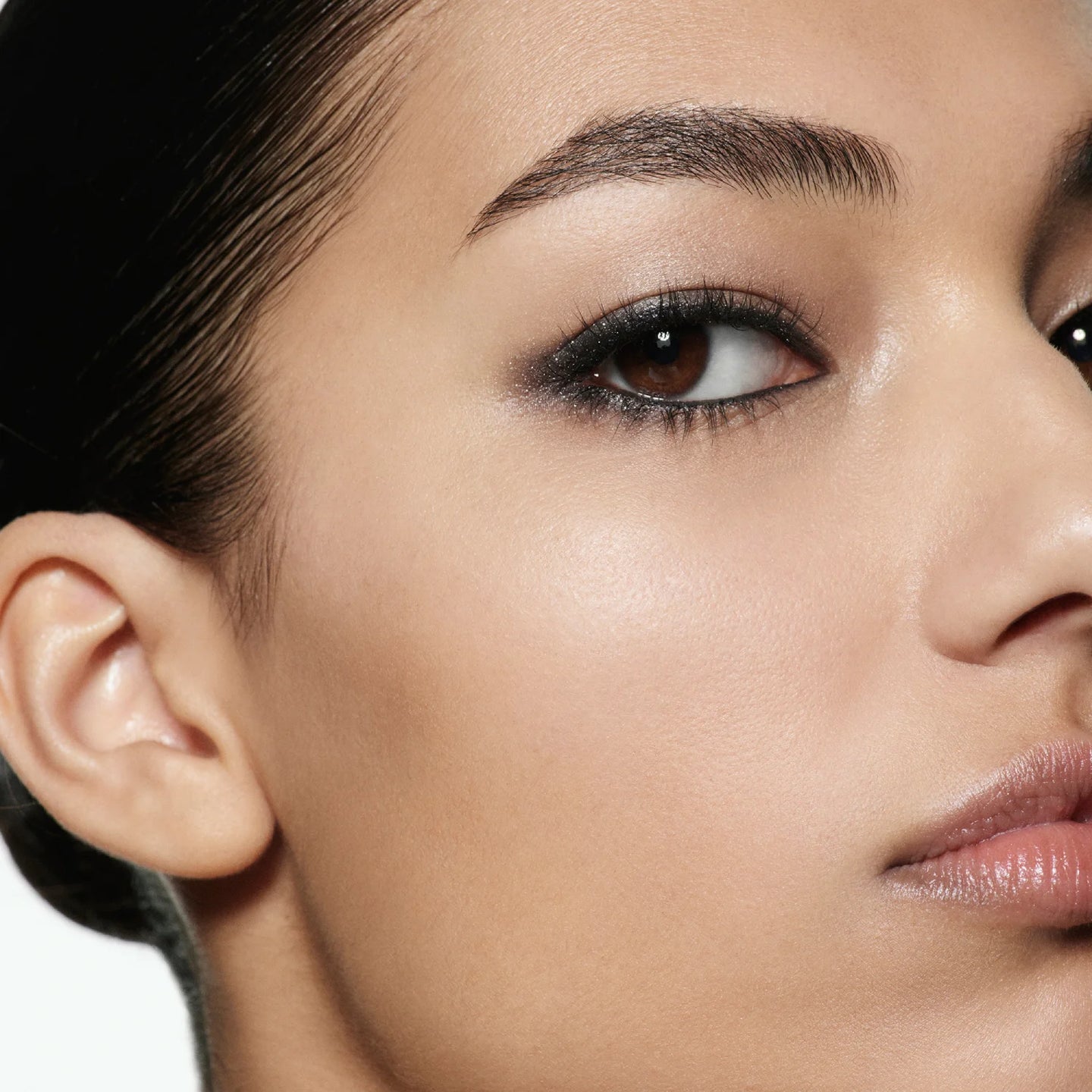 Close-up model shot wearing Victoria Beckham Beauty Eye Wardrobe in Night Flash – a refined smoky eye look featuring deep black, shimmering taupe, and soft ivory tones for a sultry, elegant finish.