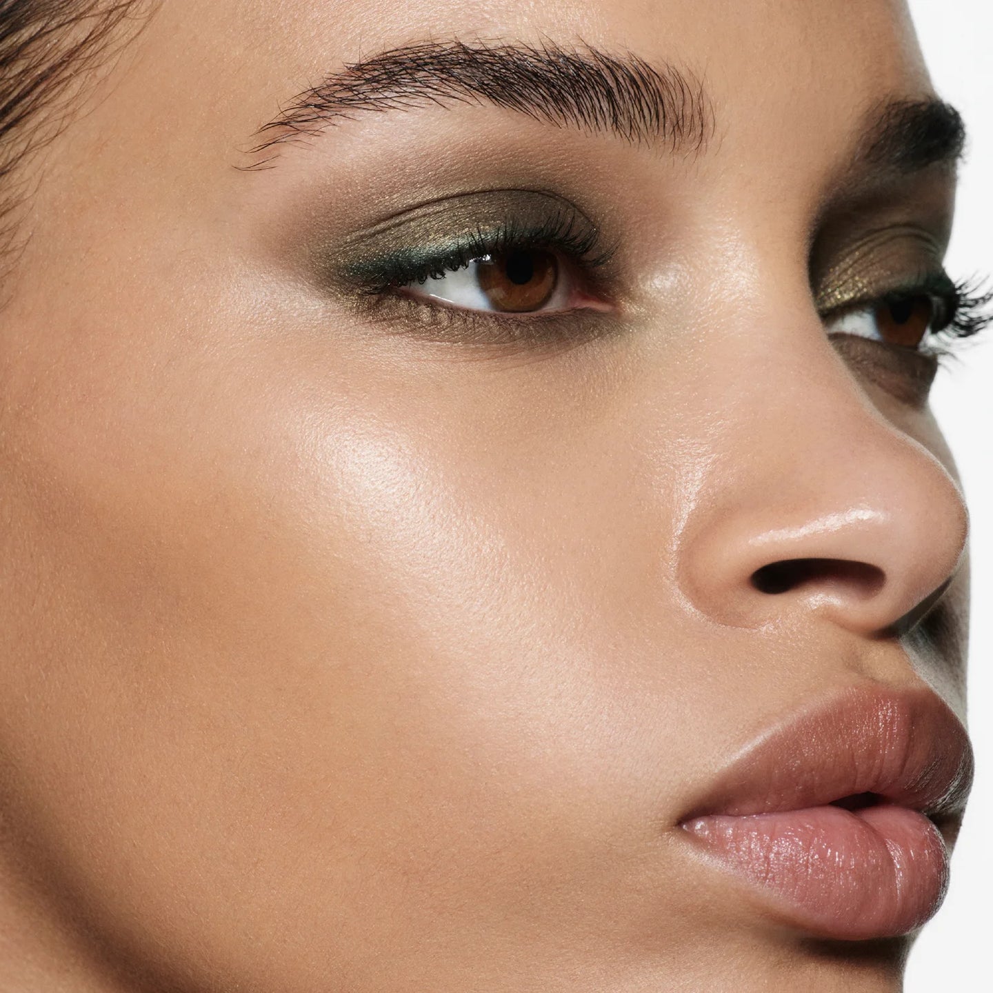 Close-up model shot wearing Victoria Beckham Beauty Eye Wardrobe in Olive – a luxurious eyeshadow look featuring deep green, bronze, and gold tones for a soft, smoky finish.