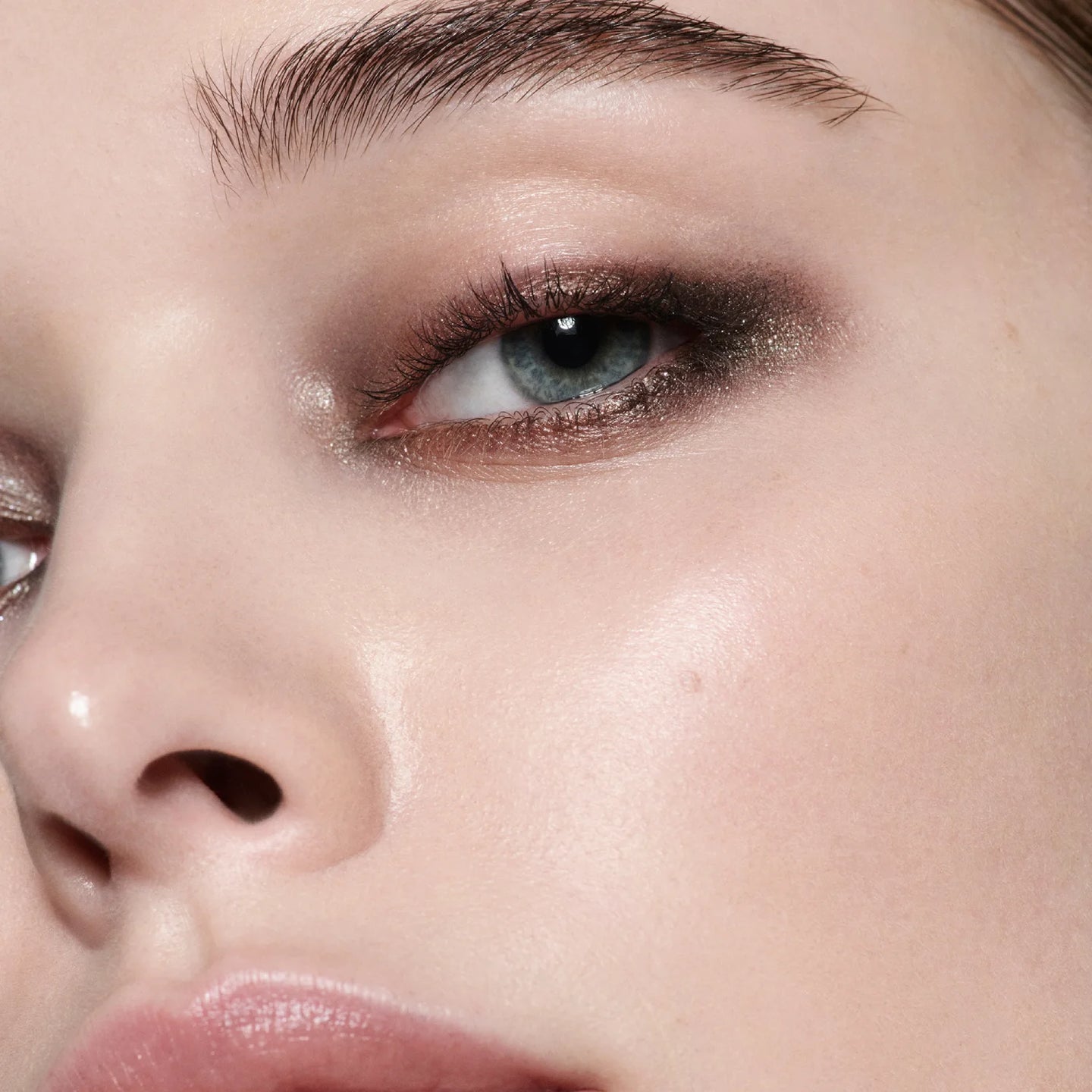Close-up model shot wearing Victoria Beckham Beauty Eye Wardrobe in Victoria – a refined eyeshadow look featuring soft beige, shimmering bronze, deep espresso, and warm brown tones for an elegant, smoky finish.