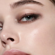 Close-up model shot wearing Victoria Beckham Beauty Eye Wardrobe in Victoria – a refined eyeshadow look featuring soft beige, shimmering bronze, deep espresso, and warm brown tones for an elegant, smoky finish.