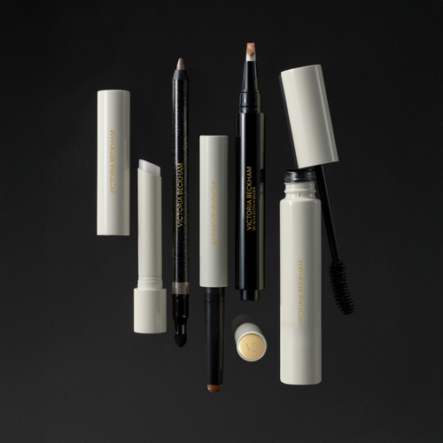 Victoria Beckham Beauty essentials floating on black — stylus pencils, eyeliner, brow pen and mascara wand.