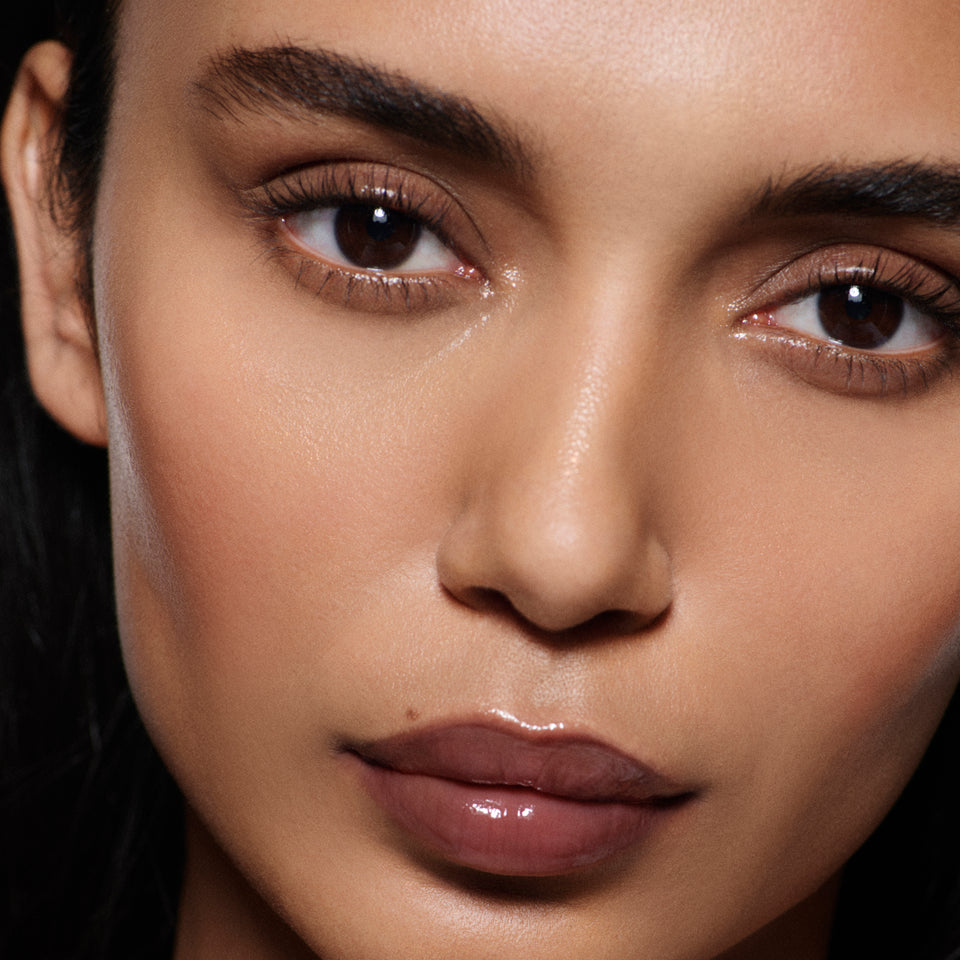 Close-up of tan lips in Posh Gloss TopDown — Victoria Beckham Beauty's deep mahogany high-shine lip gloss.