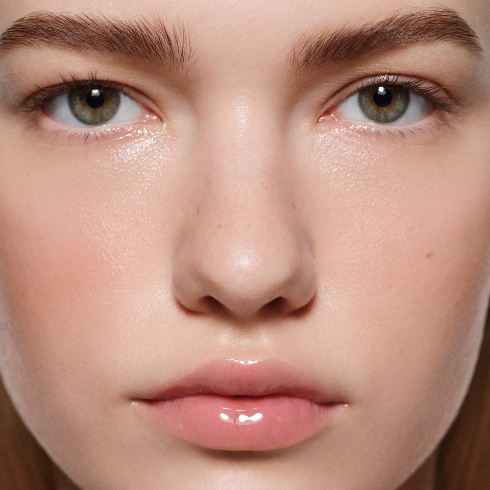 Close-up of fair lips in Posh Gloss Ice — Victoria Beckham Beauty's clear, mirror-shine lip gloss for a glassy finish.