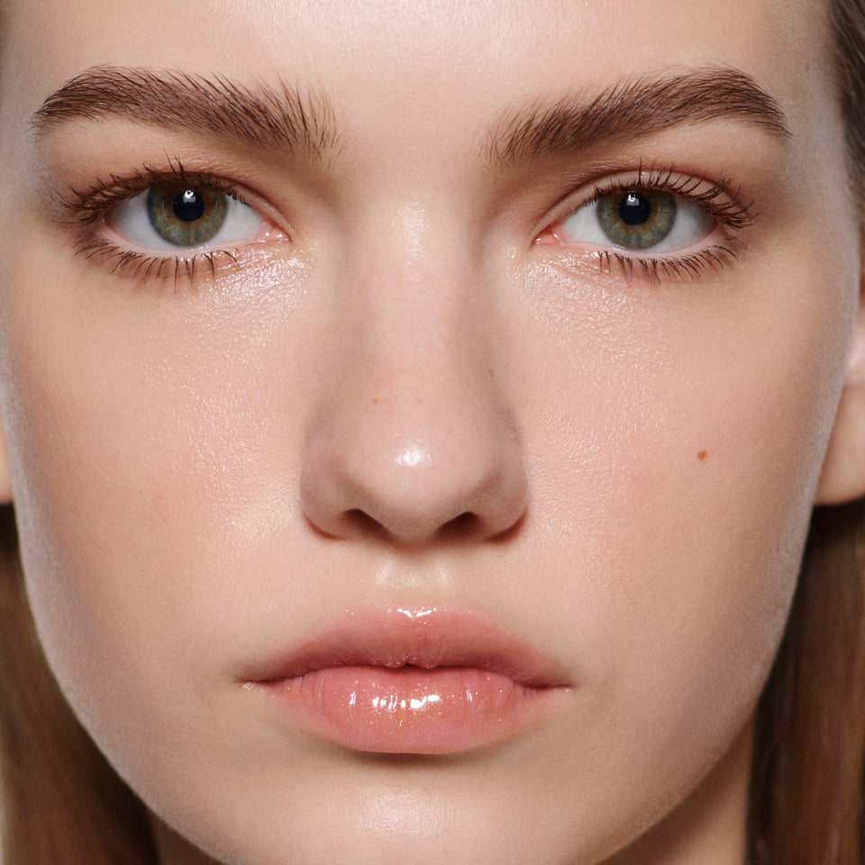 Close-up of fair lips in Posh Balm Soleil — Victoria Beckham Beauty's golden bronze shimmer tinted lip balm.