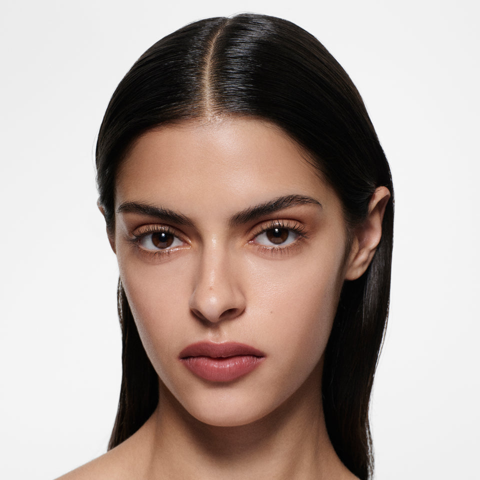 Olive-complexion model with centre-parted dark hair in Lip Definer No. 03 — berry pink-rose by Victoria Beckham Beauty.