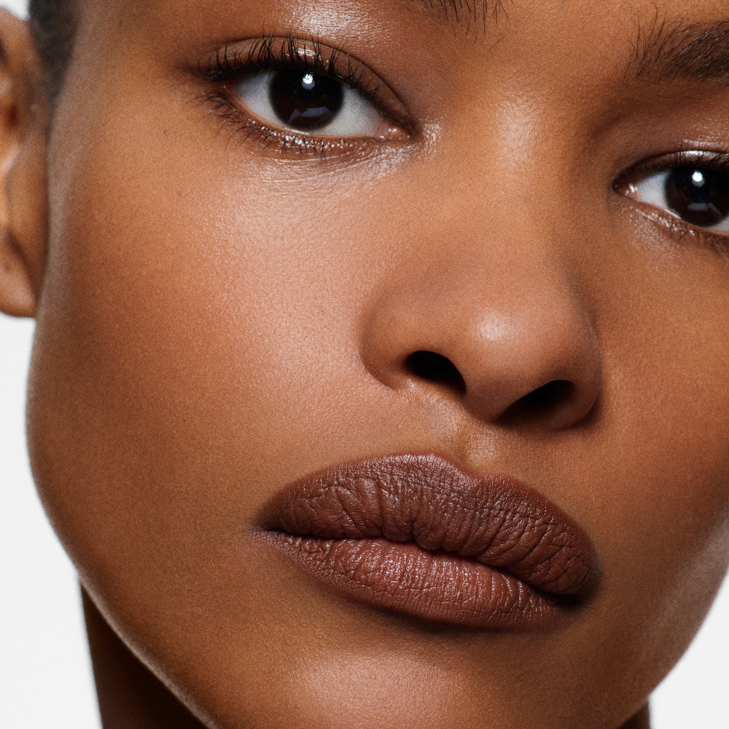 Close-up of deep-complexion lips lined in Lip Definer No. 05 — Victoria Beckham Beauty's cocoa brown lip pencil.