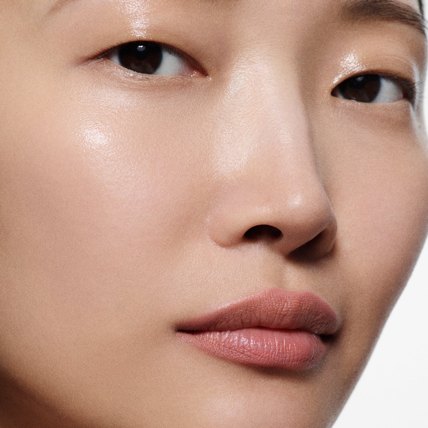 Close-up of tan lips lined in Lip Definer No. 01 — Victoria Beckham Beauty's dusty peach-rose lip pencil.