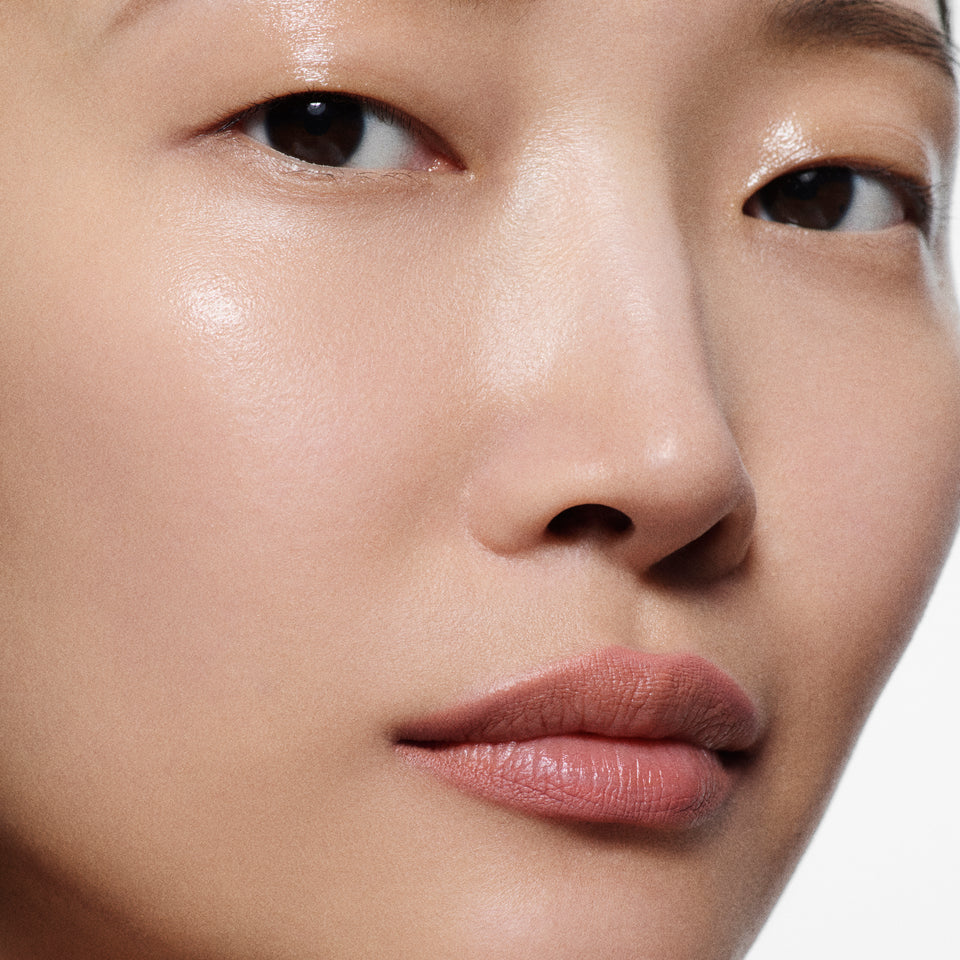 Close-up of tan lips lined in Lip Definer No. 01 — Victoria Beckham Beauty's dusty peach-rose lip pencil.