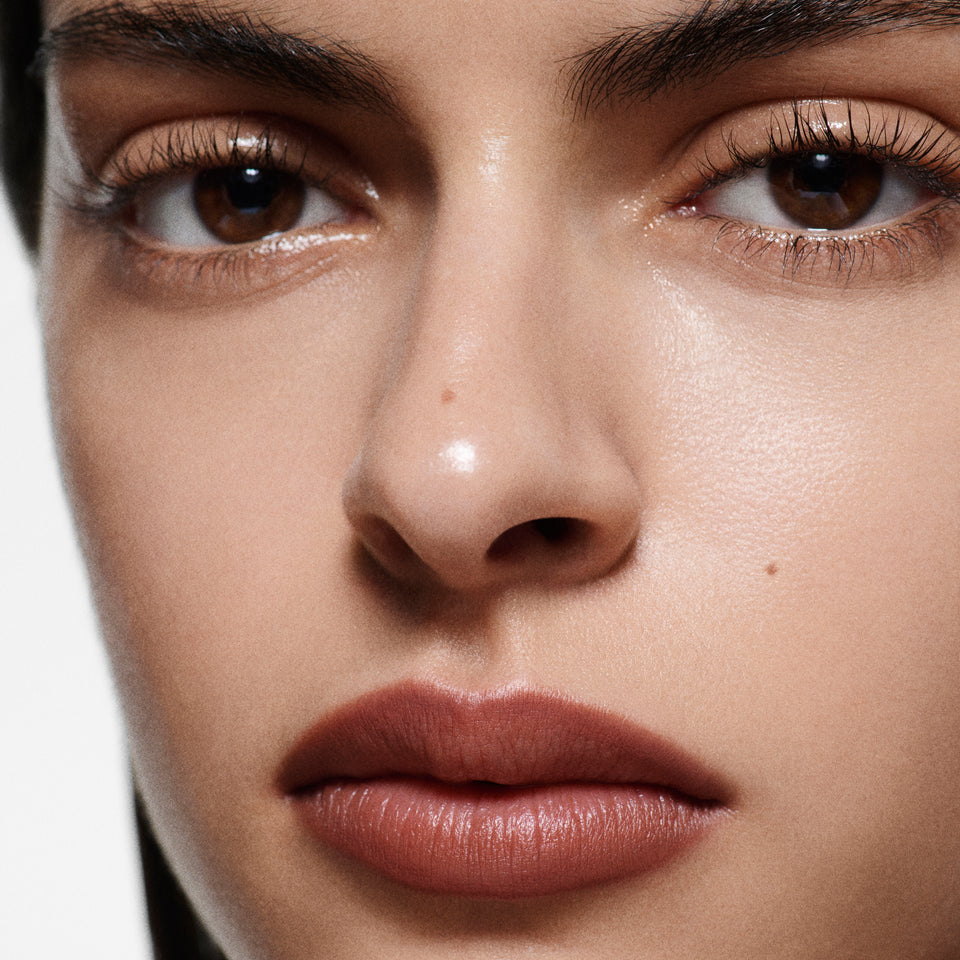 Close-up of olive-toned lips lined in Lip Definer No. 04 — Victoria Beckham Beauty's brick red-brown lip pencil.