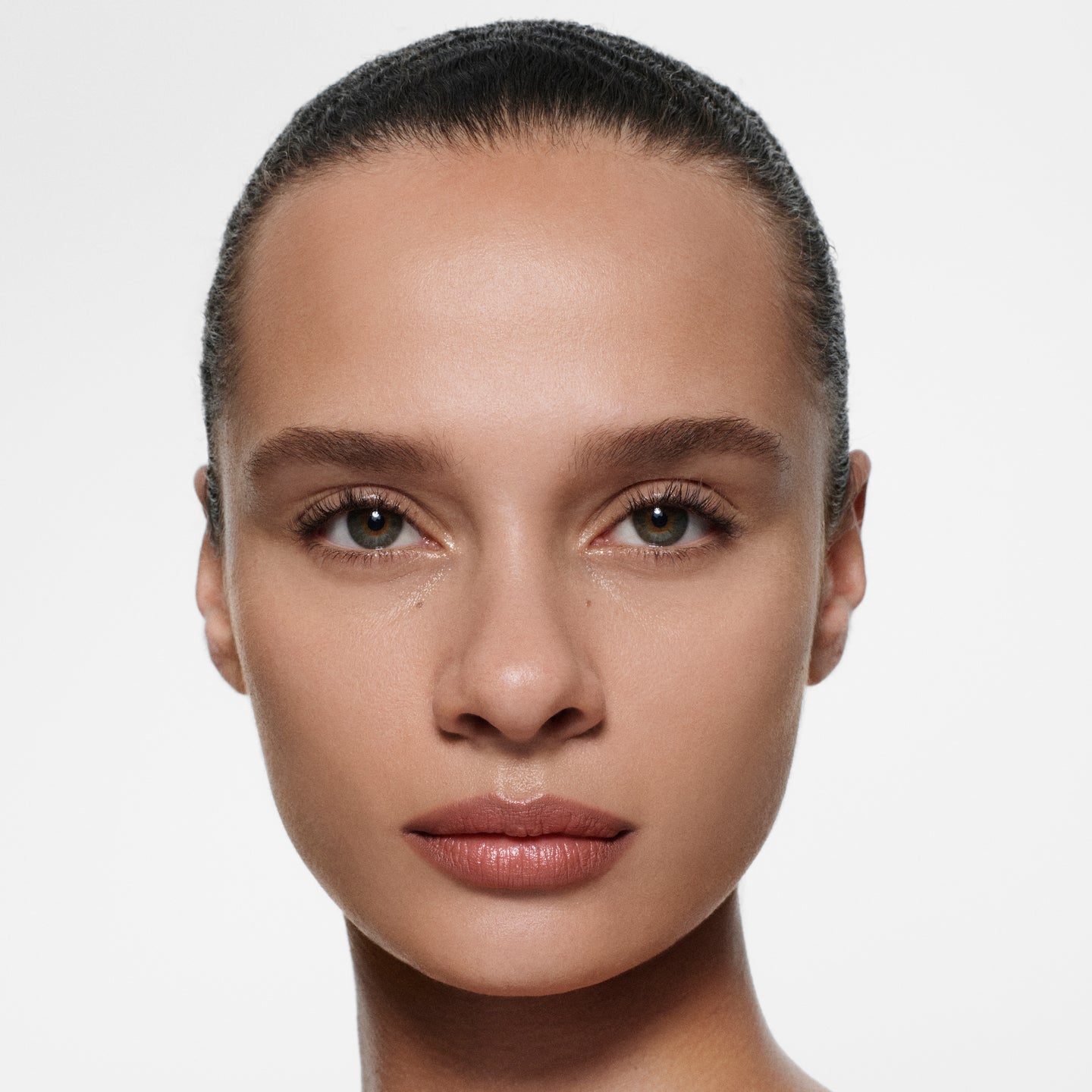 Tan-complexion model with slicked-back dark hair in Lip Definer No. 02 — warm rosewood by Victoria Beckham Beauty.