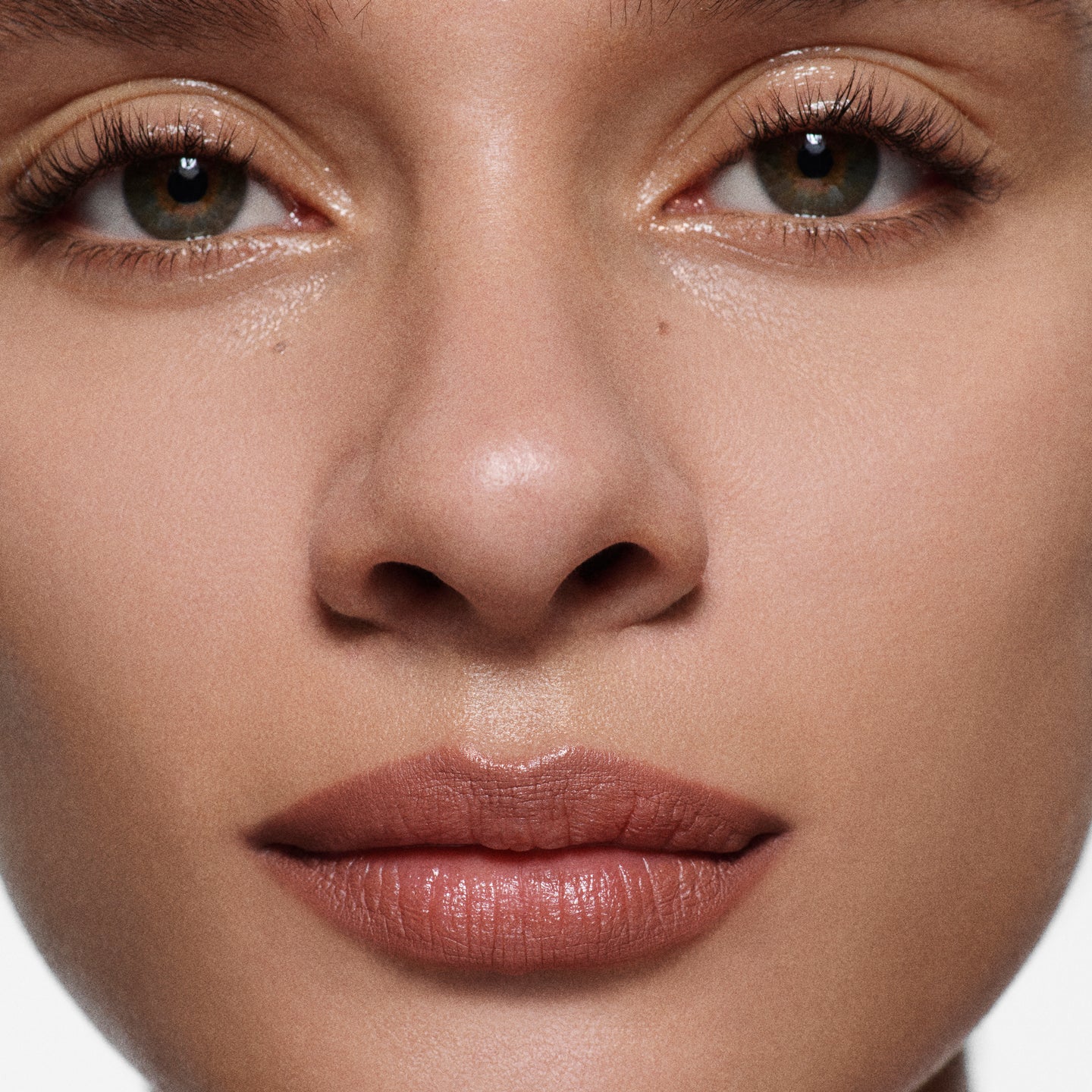 Close-up of tan lips lined in Lip Definer No. 02 — Victoria Beckham Beauty's warm rosewood lip pencil.