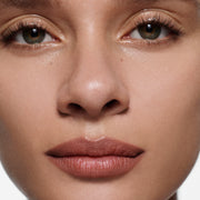 Close-up of tan lips lined in Lip Definer No. 02 — Victoria Beckham Beauty's warm rosewood lip pencil.