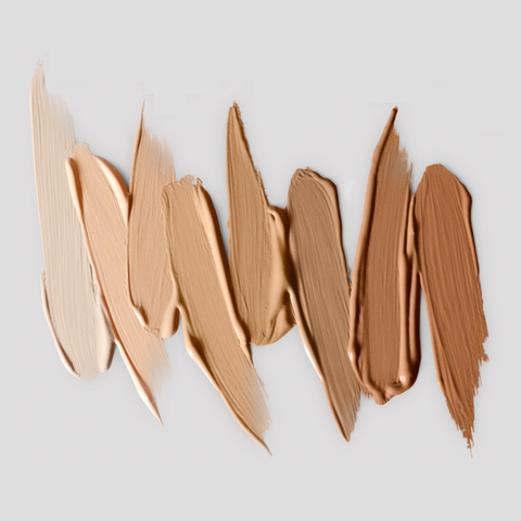 Victoria Beckham Beauty concealer swatches in a gradient of shades from fair to medium, showcasing the creamy and blendable texture on a neutral background.