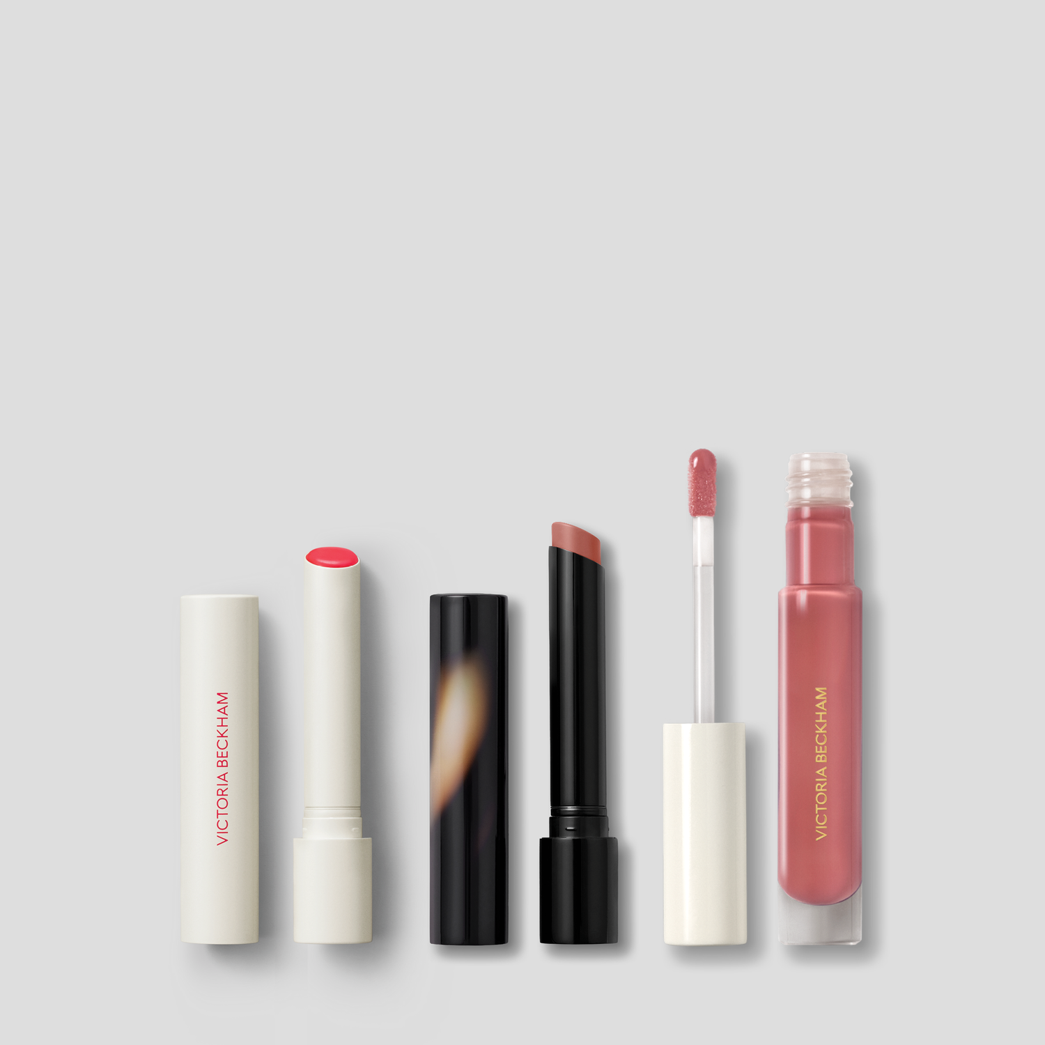 Three-product lip edit: coral satin lipstick, rosewood matte lipstick and rose Posh Gloss from Victoria Beckham Beauty.