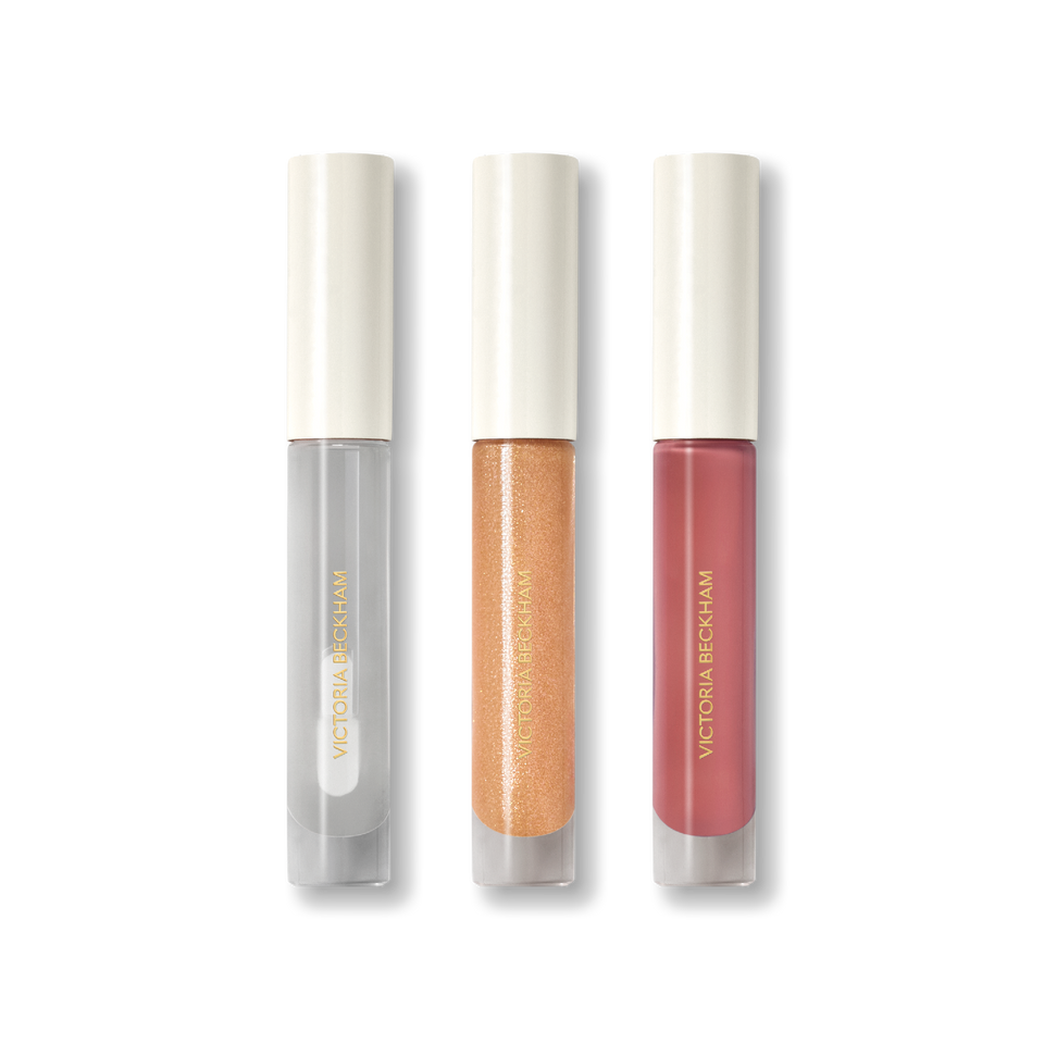 Three Posh Gloss tubes on black — Ice, Martini and Cabana from Victoria Beckham Beauty's high-shine lip gloss range.