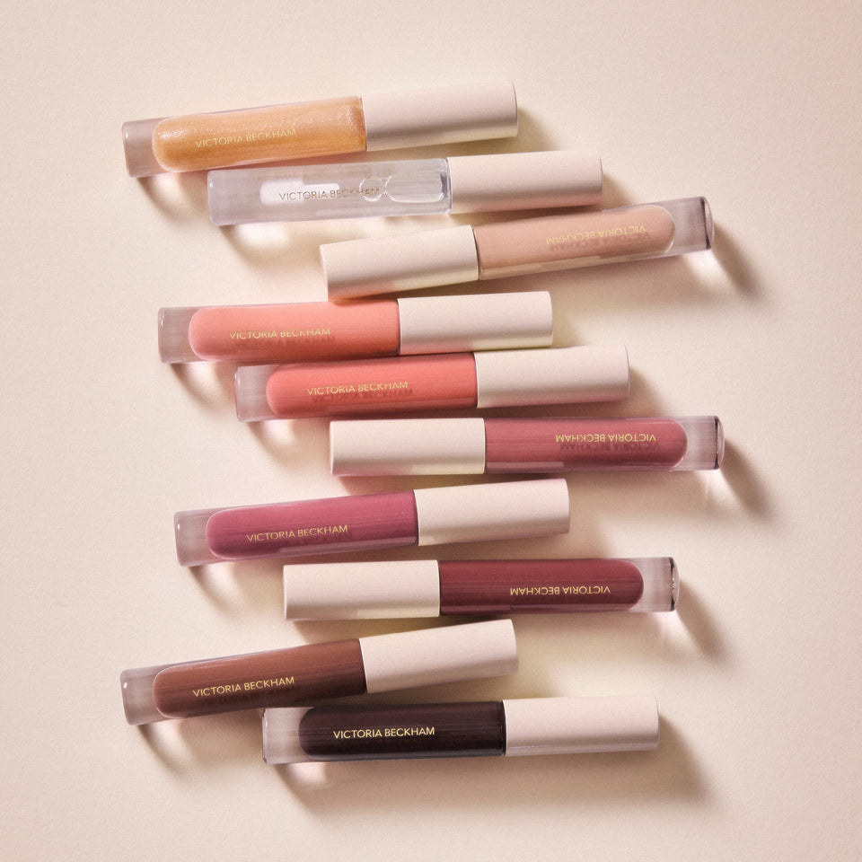 Ten Posh Gloss tubes laid in a flowing zigzag — Victoria Beckham Beauty's complete high-shine lip gloss shade range.