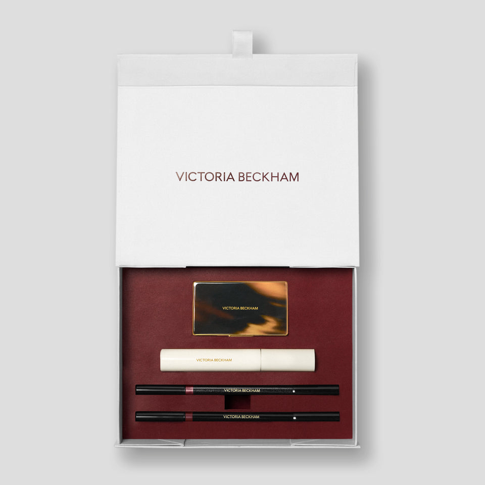 Open Bordeaux Eye Kit gift box with tortoiseshell compact, mascara and two pencils on burgundy — Victoria Beckham Beauty.