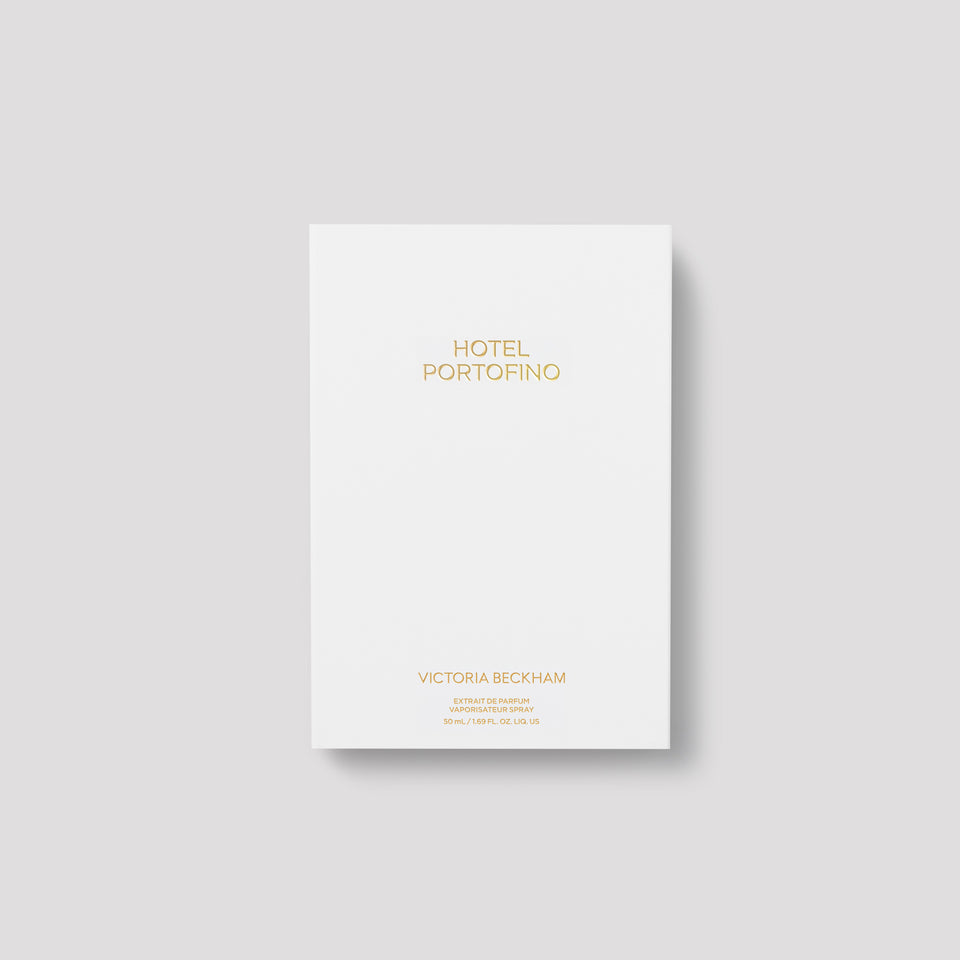 Closed white Hotel Portofino carton with gold lettering on grey — the 50 mL Extrait de Parfum by Victoria Beckham Beauty.