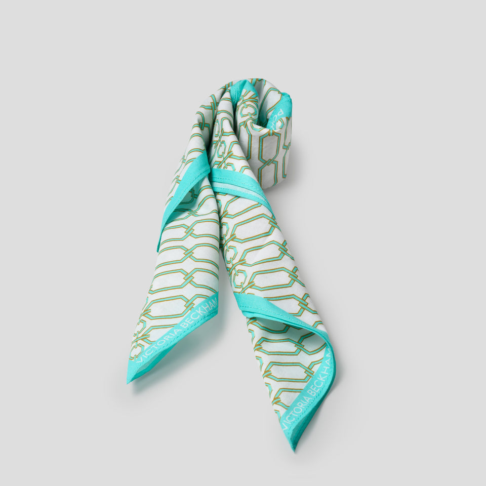 Rolled up scarf with light blue border and chain pattern on grey background 