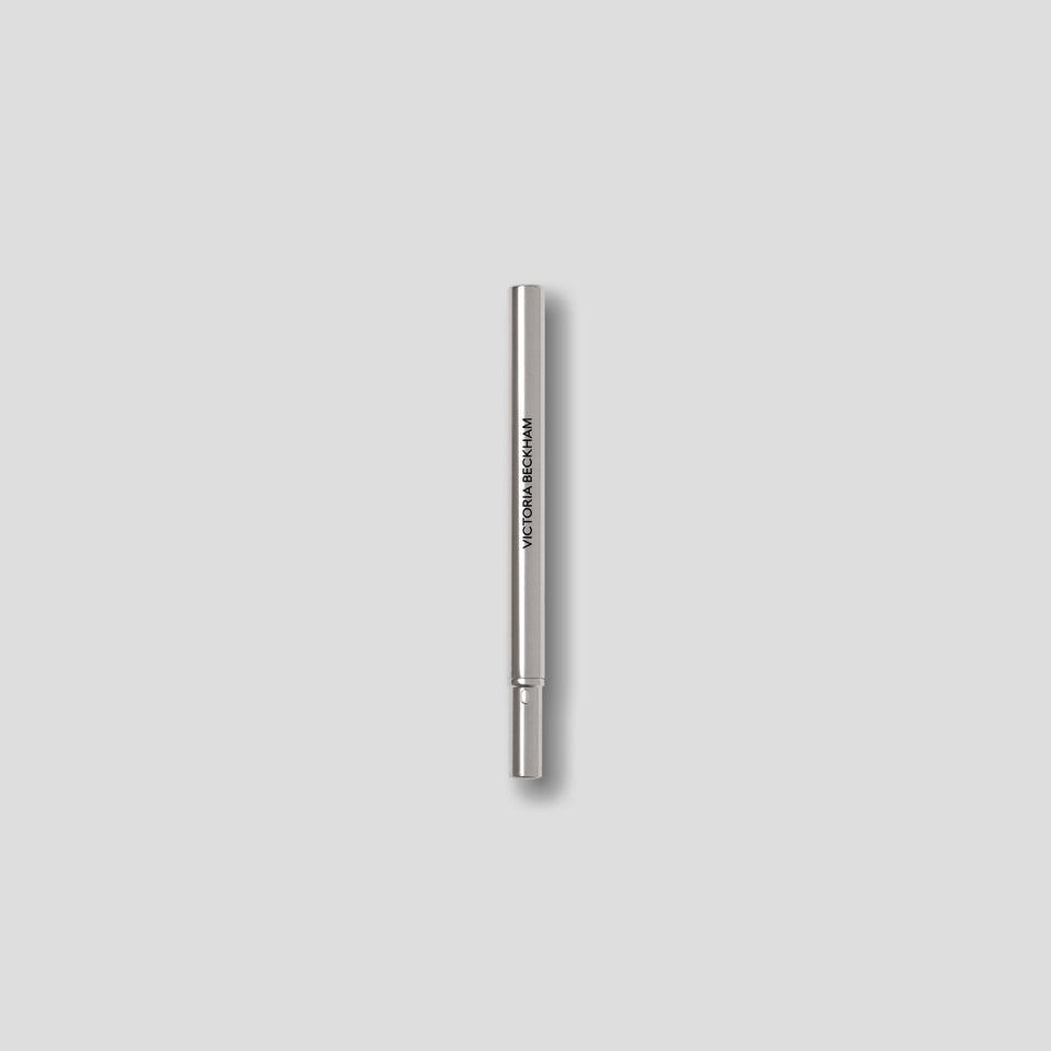Closed Victoria Beckham Beauty Lip Definer pencil — sleek silver cap posted on the sharpener-topped barrel.
