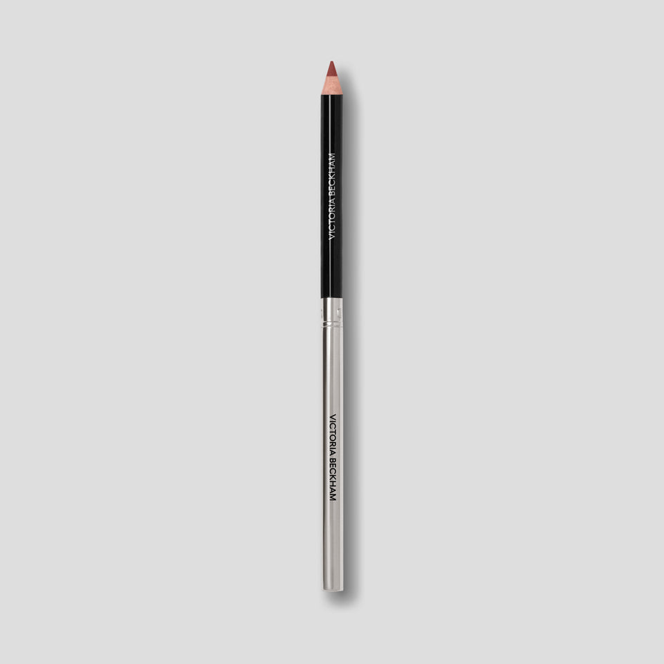 Victoria Beckham Beauty Lip Definer pencil in No. 04 — black barrel and silver base tipped in brick red-brown.
