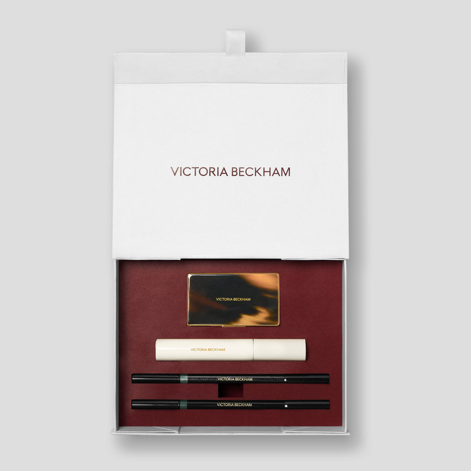 Open Olive Eye Kit gift box with tortoiseshell compact, mascara and two pencils on burgundy — Victoria Beckham Beauty.