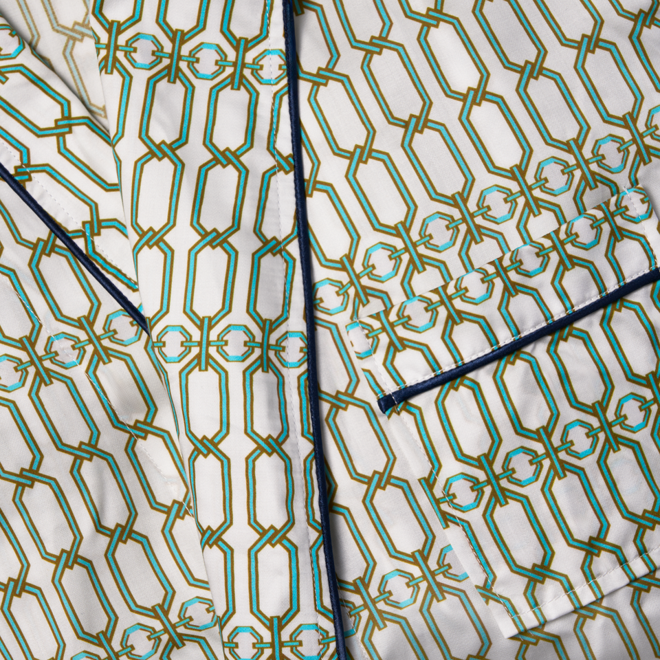 Macro of the Portofino '97 robe's collar and pocket, navy piping on turquoise and gold chain-link silk.