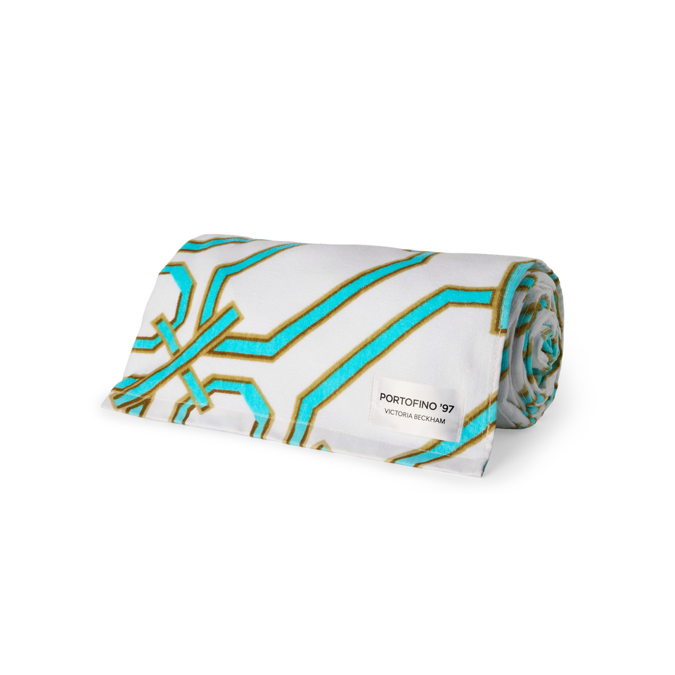 Rolled Portofino '97 beach towel in turquoise and gold chain-link print, by Victoria Beckham Beauty.