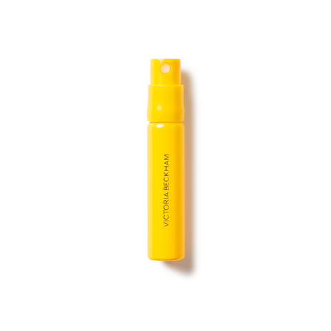 Bright yellow fragrance atomizer bottle with "Victoria Beckham" text and spray nozzle.